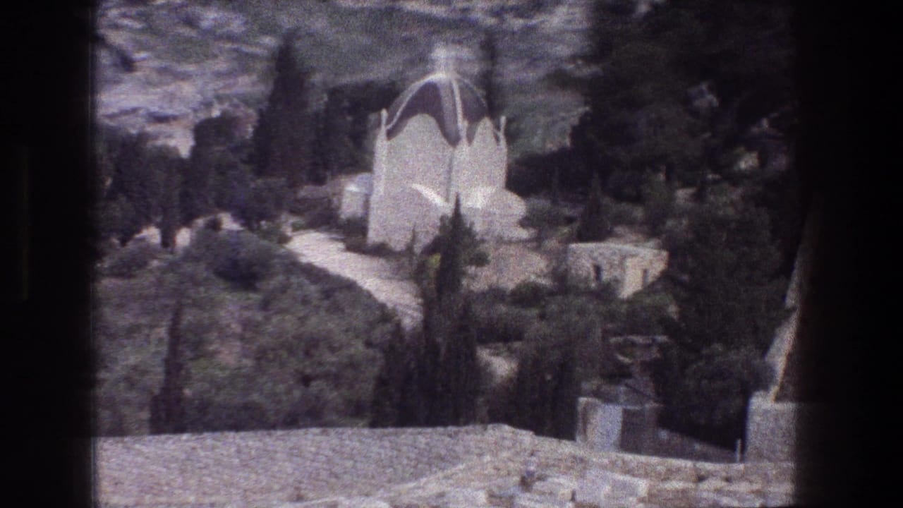 1976 8mm Jerusalem view of a white domed mausoleum or tomb set among cypress-like trees, shrubs, rocks, and stone paths.
