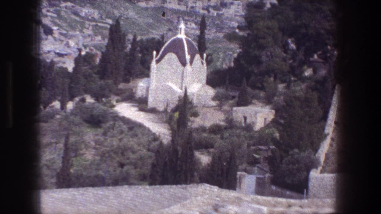 White domed chapel among trees on a Jerusalem hillside.