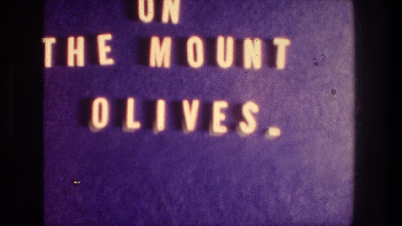 Repeated 1976 8mm title card for the Mount of Olives sequence, with soft focus and visible film grain.