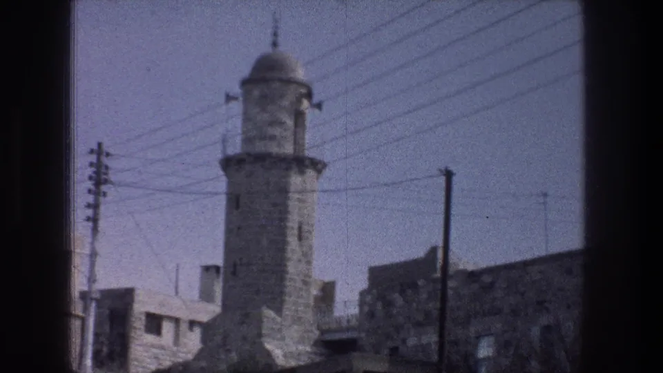 A final 1976 Jerusalem view holds on the domed stone tower, with overhead lines and adjacent masonry buildings in frame.