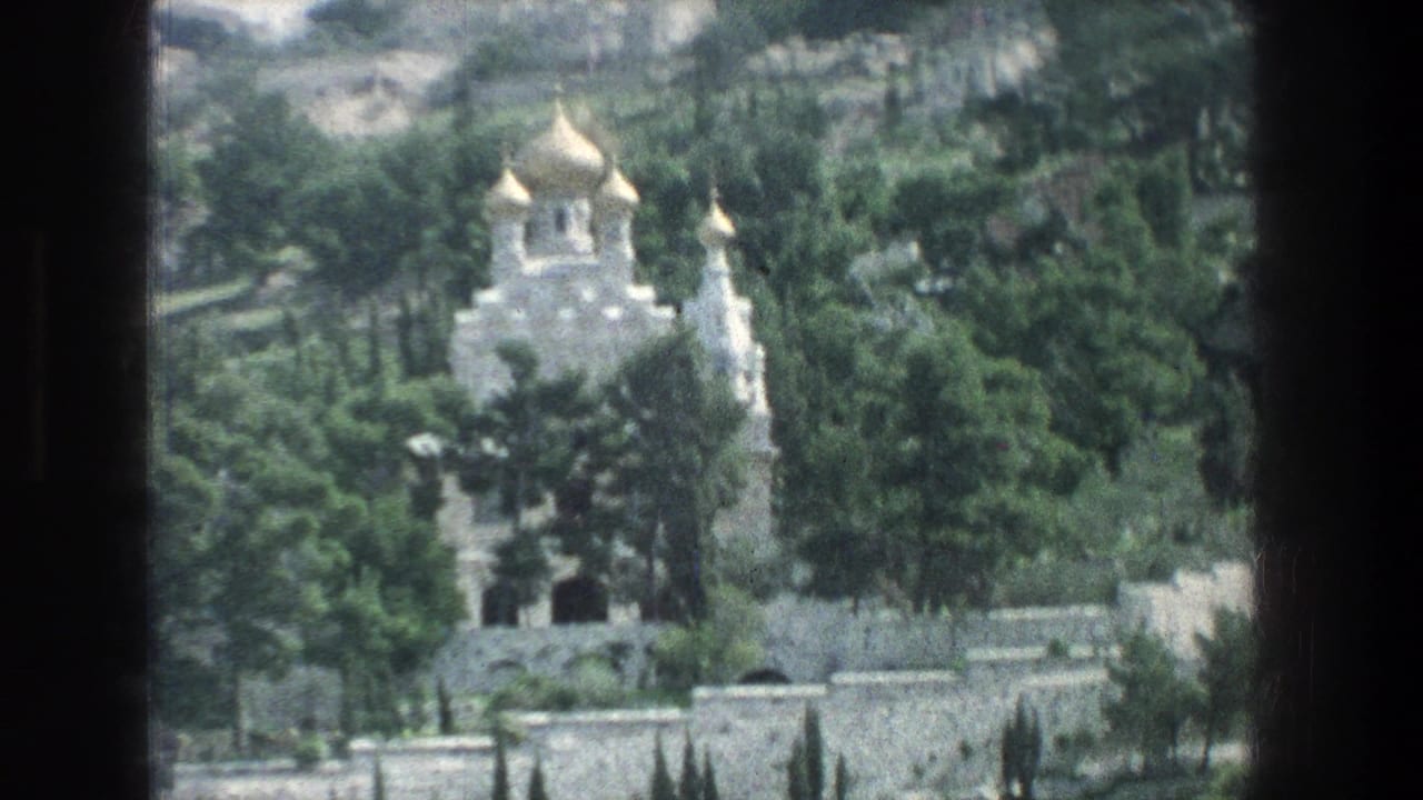 1976 Jerusalem footage shows a golden-domed hillside building partly obscured by trees and viewed from a moving vehicle.