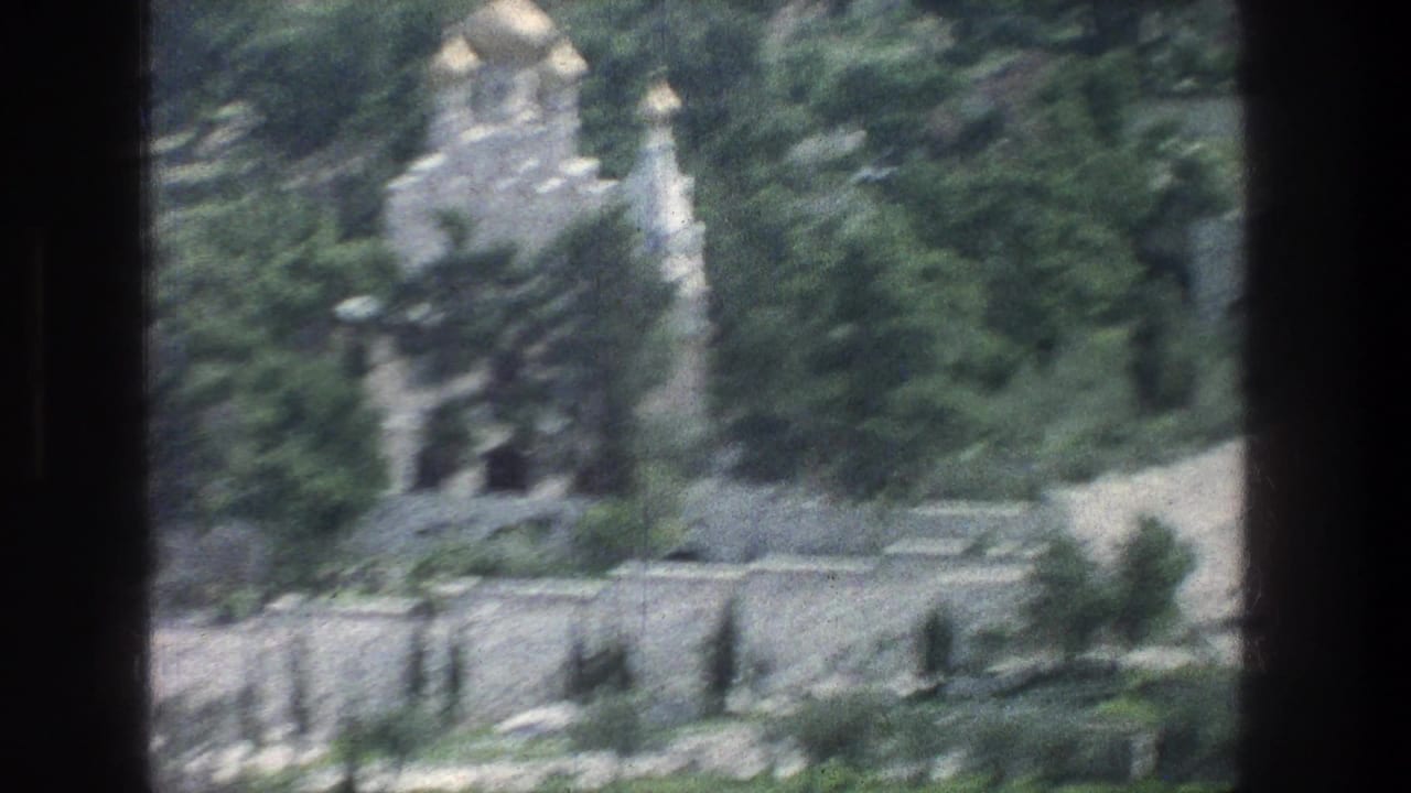 Similar distant view of a stone tomb and trees divided by dark frame bars.