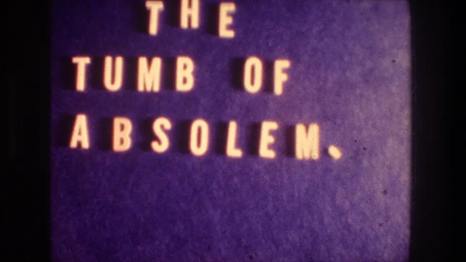 Close title-card frame from the 8mm reel, showing "THE TUMB OF ABSOLEM" against a purple field.