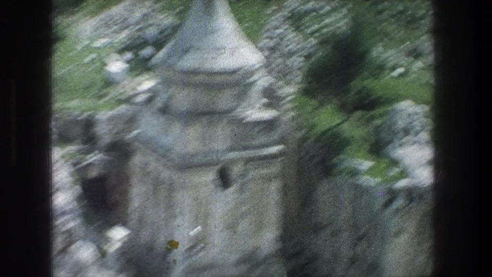 Motion-blurred 1976 8mm Jerusalem frame showing the conical stone structure and ruins during a quick handheld move.