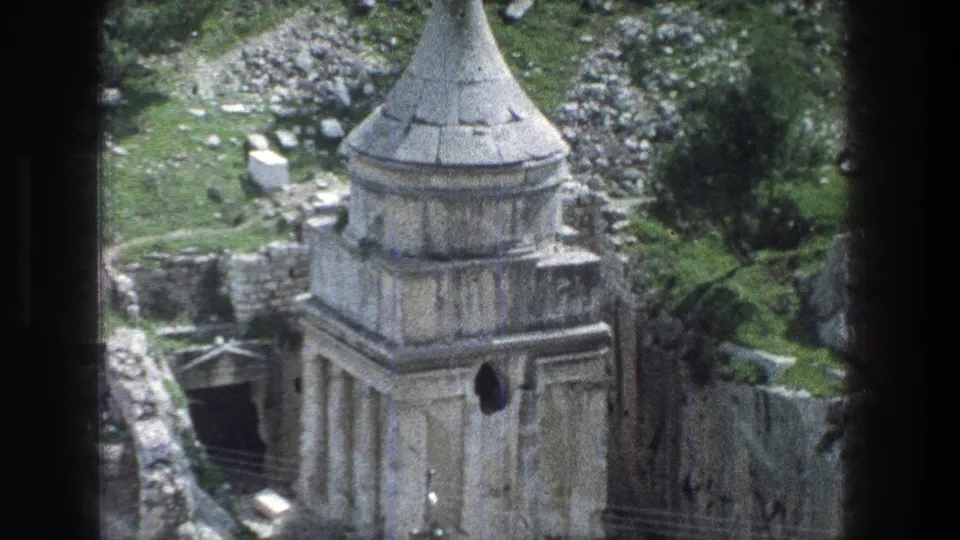 1976 Jerusalem frame of the same stone ruin, with its conical top, dark side entrance, broken masonry, and hillside vegetation.