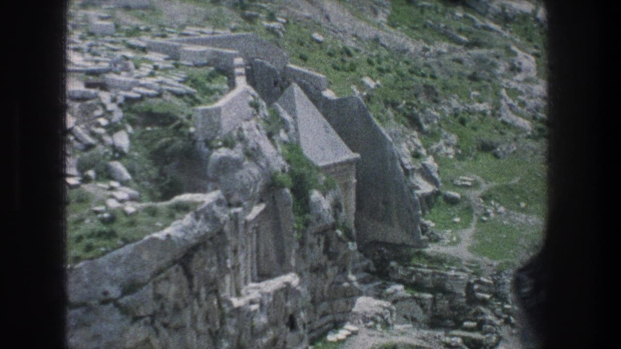 Aerial view of stone walls, ruins, and a small roofed structure.