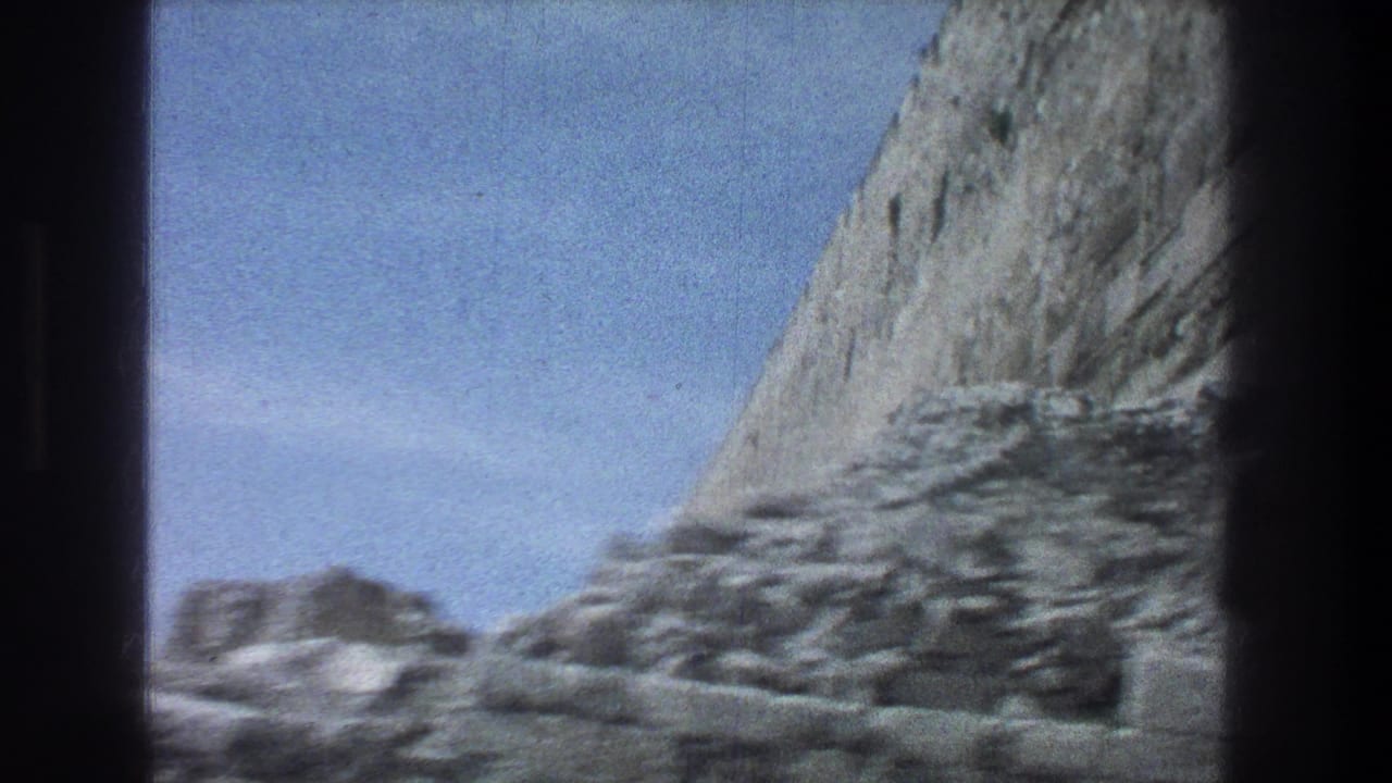 Stone wall and lower rubble seen beneath open sky.
