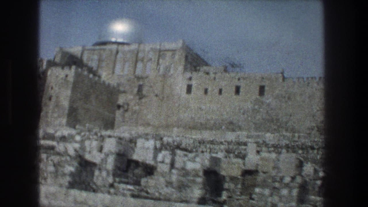 Silver dome rising above ancient stone walls and foreground ruins.