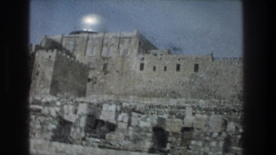 1976 8mm view of the silver dome above stone walls and ruins in Jerusalem, seen from a visitor vantage point.