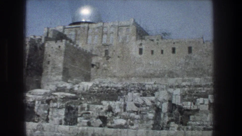 Vintage 1976 Jerusalem home-movie frame showing a domed religious landmark above massive stone walls and rubble.
