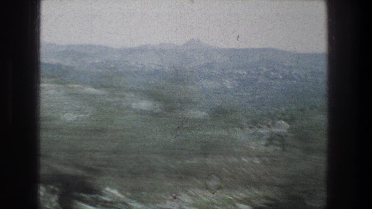 1976 8mm travel view near Jerusalem, Israel, looking past a dark window frame toward hazy hills and scrubby trees.