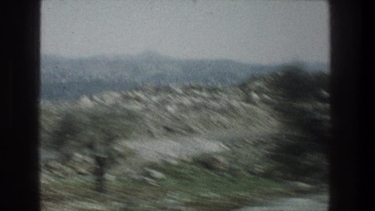 Moving 8mm travel view of rocky Jerusalem-area terrain, with scrub, distant hills, and strong motion blur.
