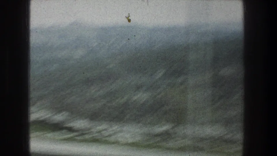Soft 1976 8mm frame showing a dry, rocky hillside near Jerusalem, Israel, filmed from a moving vehicle.