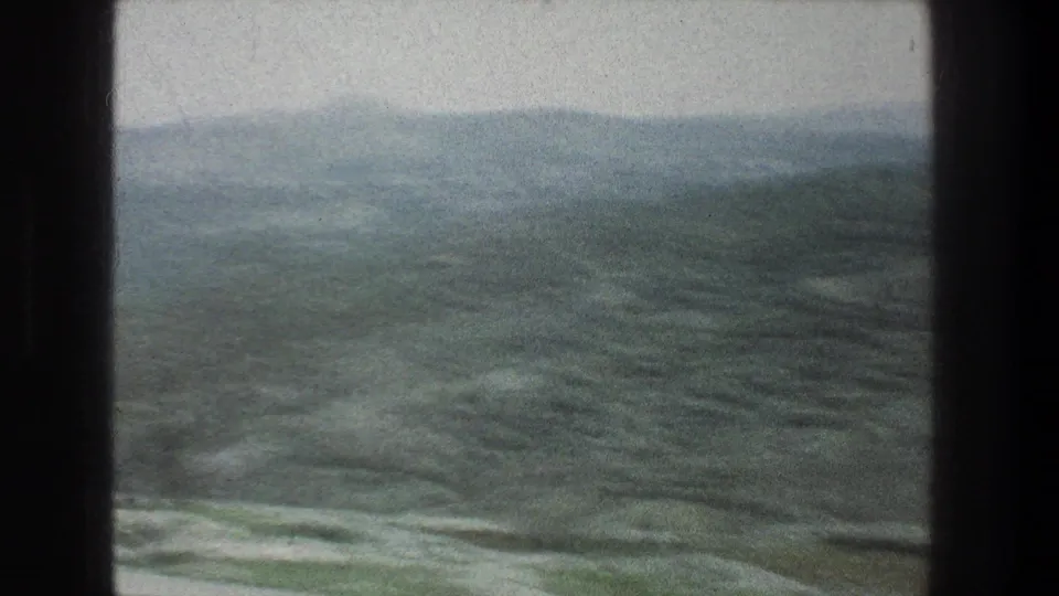 Final 8mm frame of hazy hills and scrub-covered rocky ground in the Jerusalem, Israel travel footage.
