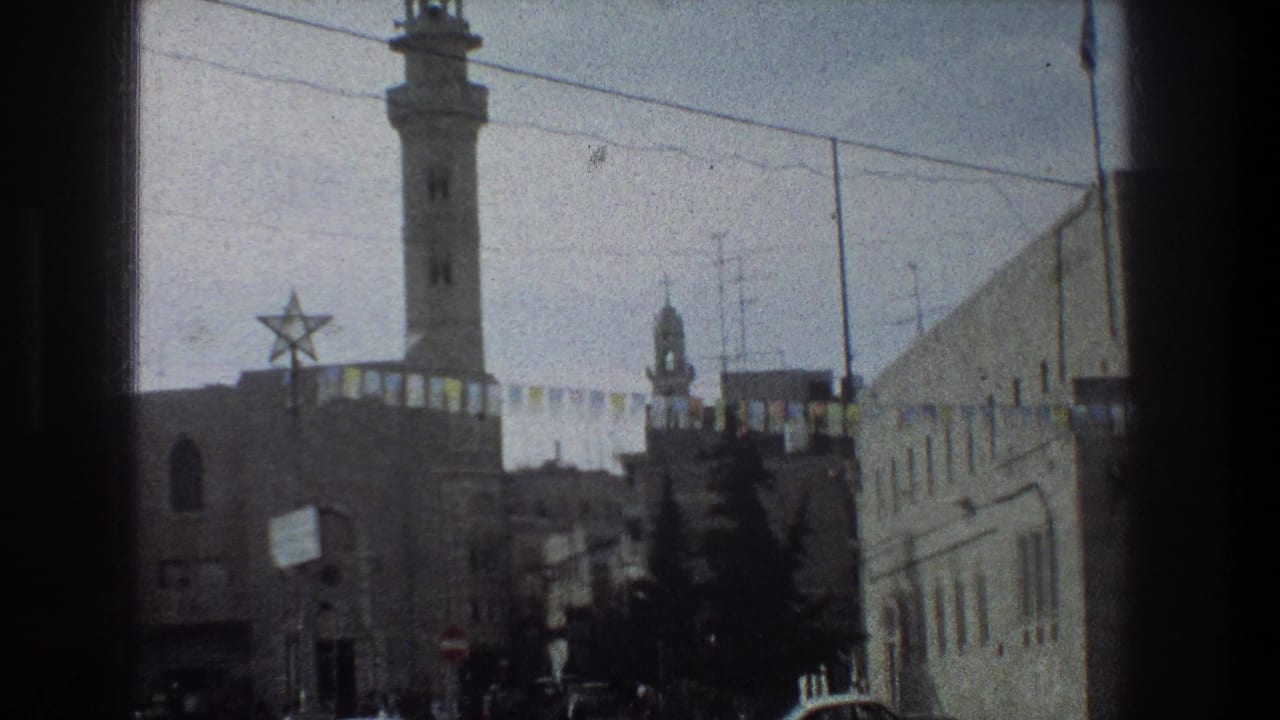 Street view with a tall minaret, Star of David decoration, bunting, buildings, and trees.
