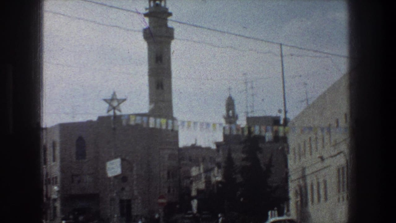 Street scene with minaret, Star of David decoration, bunting, trees, buildings, and wires.