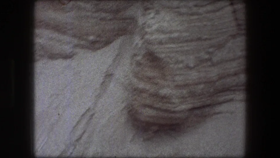 1976 Messada-area footage showing a close view of layered Judean Desert rock near the cave entrance area.