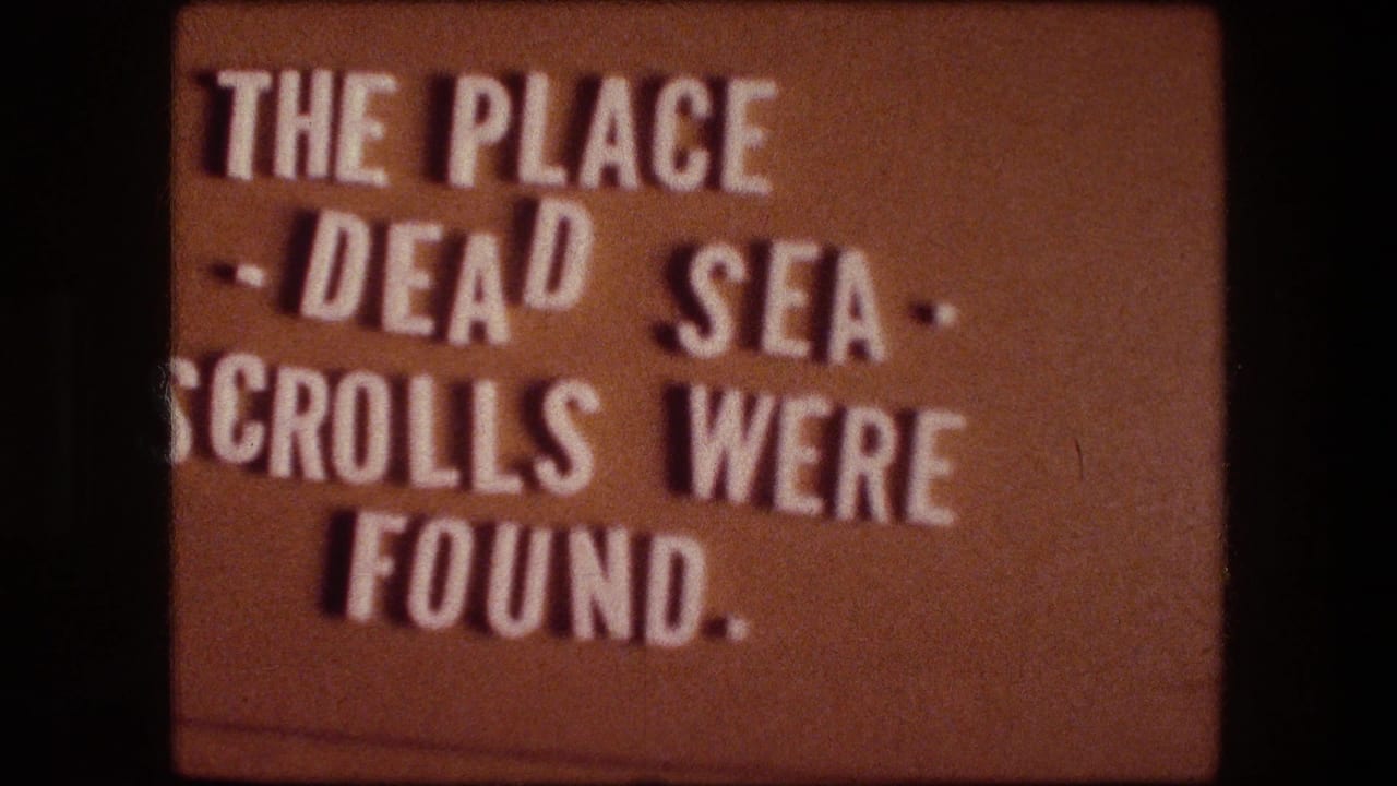 1976 8mm-style title card stating that the place is where the Dead Sea Scrolls were found.