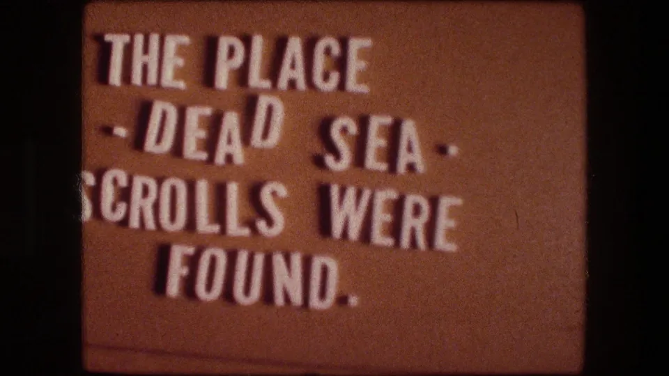 1976 8mm-style title card stating that the place is where the Dead Sea Scrolls were found.