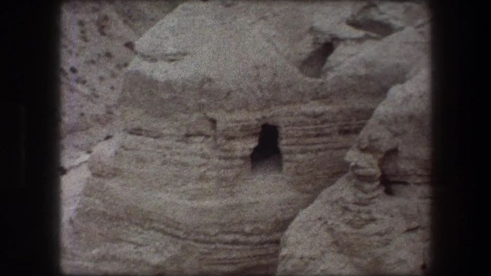 1976 8mm view at Messada, Israel, showing layered pale rock and a small dark cave-like opening in the formation.