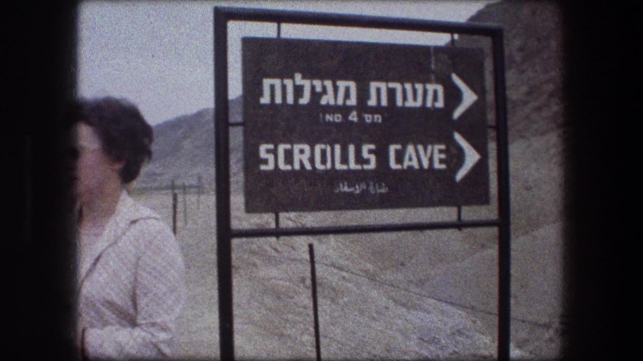 Scrolls Cave sign fills the frame with a tourist partly visible behind a dark film edge.