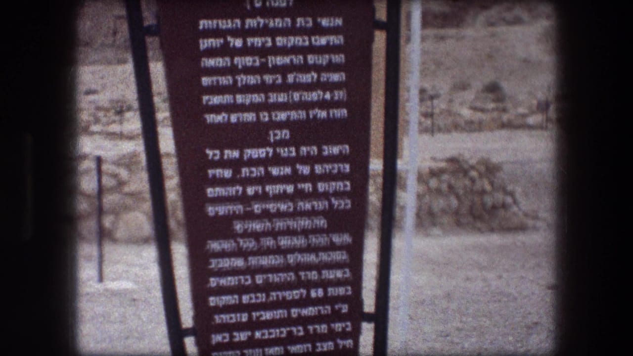 Upper portion of a Hebrew sign partially obscured by the film frame edge.