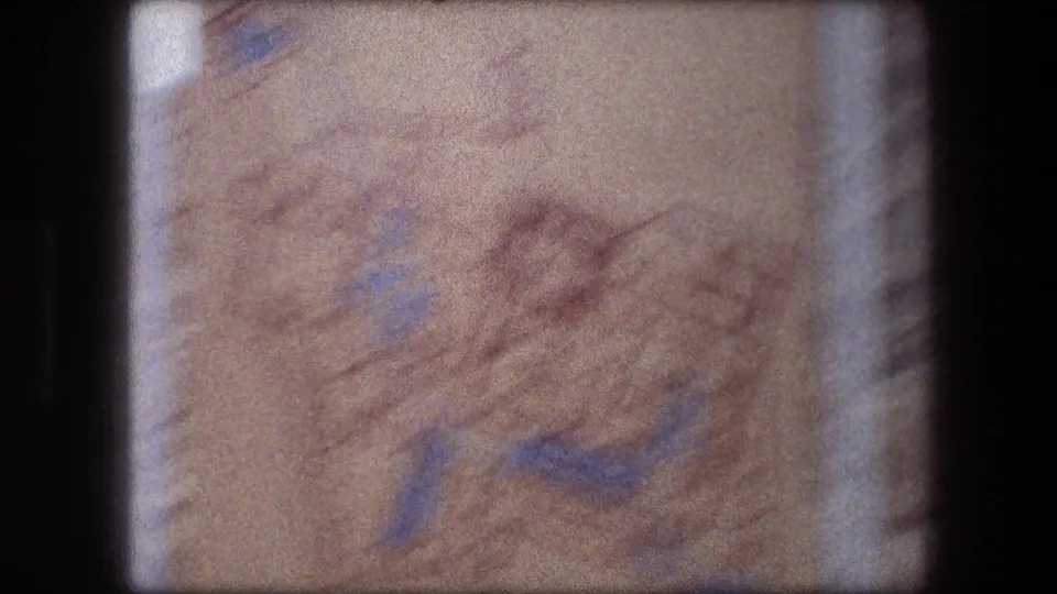 1976 8mm frame showing a blurred pale map-like or terrain display near the Messada sign sequence.