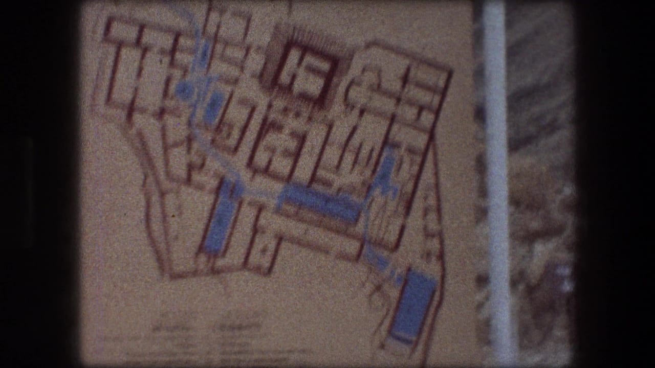 1976 Messada frame showing the upper area of a printed site map, with blue highlighted paths and orange plan lines.