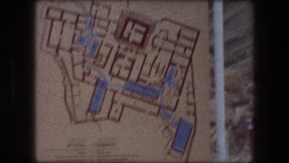 1976 Messada frame showing the upper area of a printed site map, with blue highlighted paths and orange plan lines.