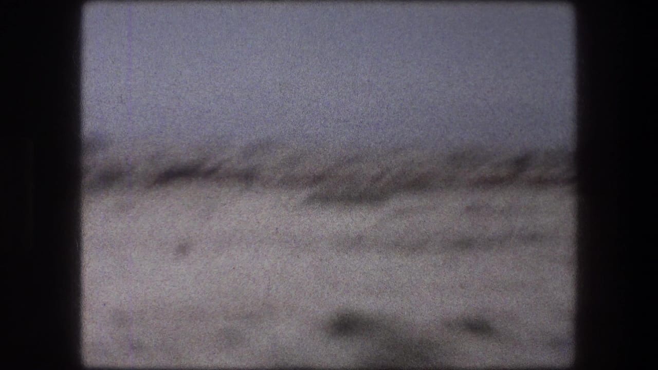 Blurred dry landscape seen through a dark train window frame.