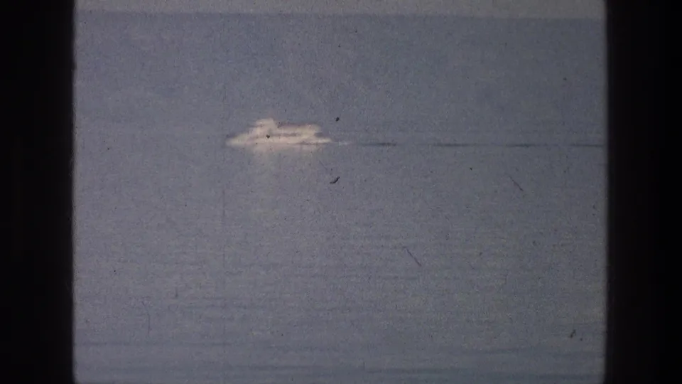 A white boat appears farther right in the Sea of Galilee frame, leaving a faint wake in soft 8mm color.
