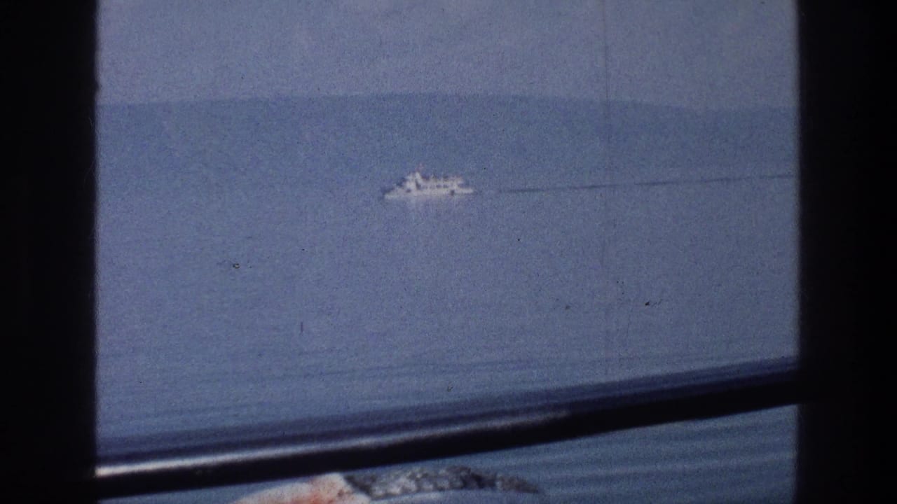 Distant white vessel on the Sea of Galilee in 1976, seen through a window with soft 8mm color and a faint wake trailing behind it.