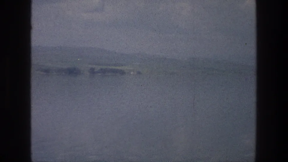 The final 1976 Sea of Galilee frame shows blue water and distant hazy land, with visible grain and dark 8mm frame edges.