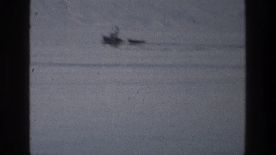 Soft 8mm view from 1976 of a small boat and narrow craft receding across the Sea of Galilee.