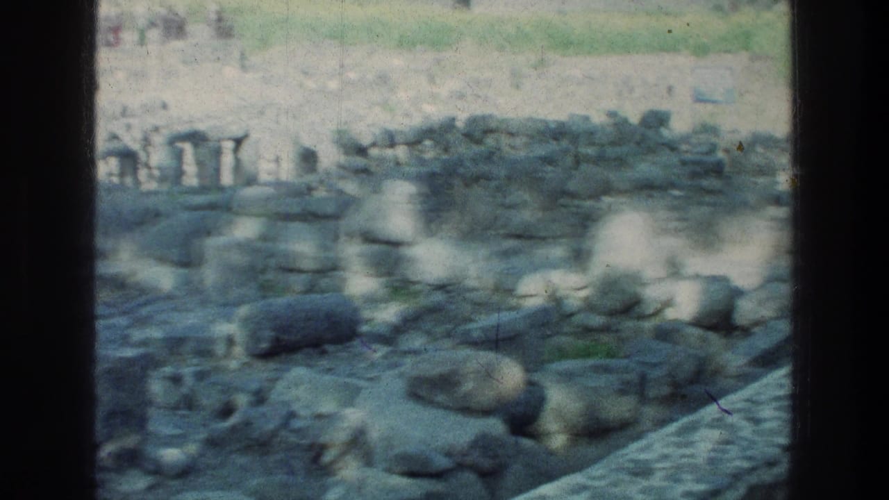 Sea of Galilee travel footage from 1976 shows weathered stones, masonry fragments, and rough paving at an archaeological site.