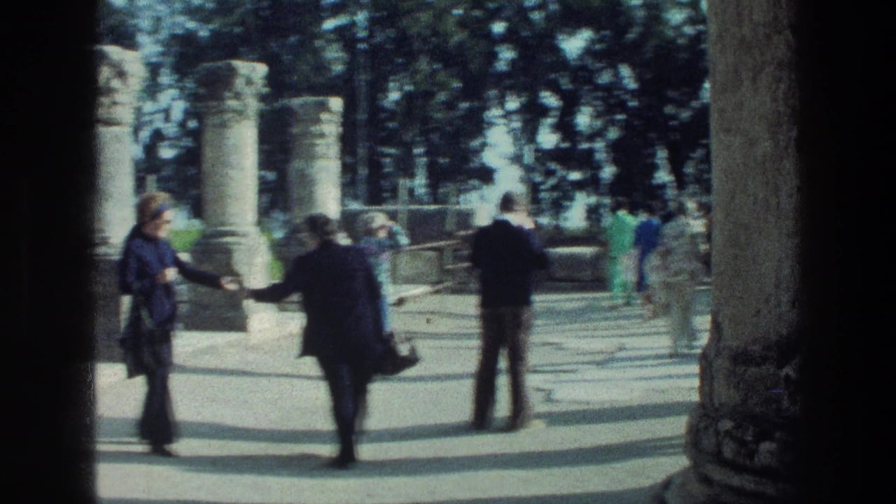At the Sea of Galilee site, visitors in 1970s clothing walk and gesture among stone columns and low ruins.