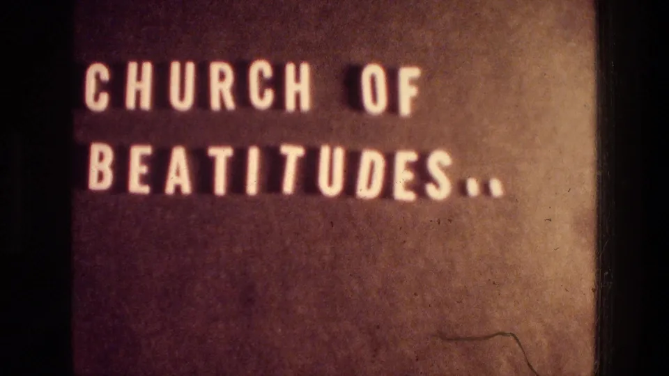 Later 8mm title-card frame reading Church of Beatitudes, with soft focus, warm color, and visible film artifacts.