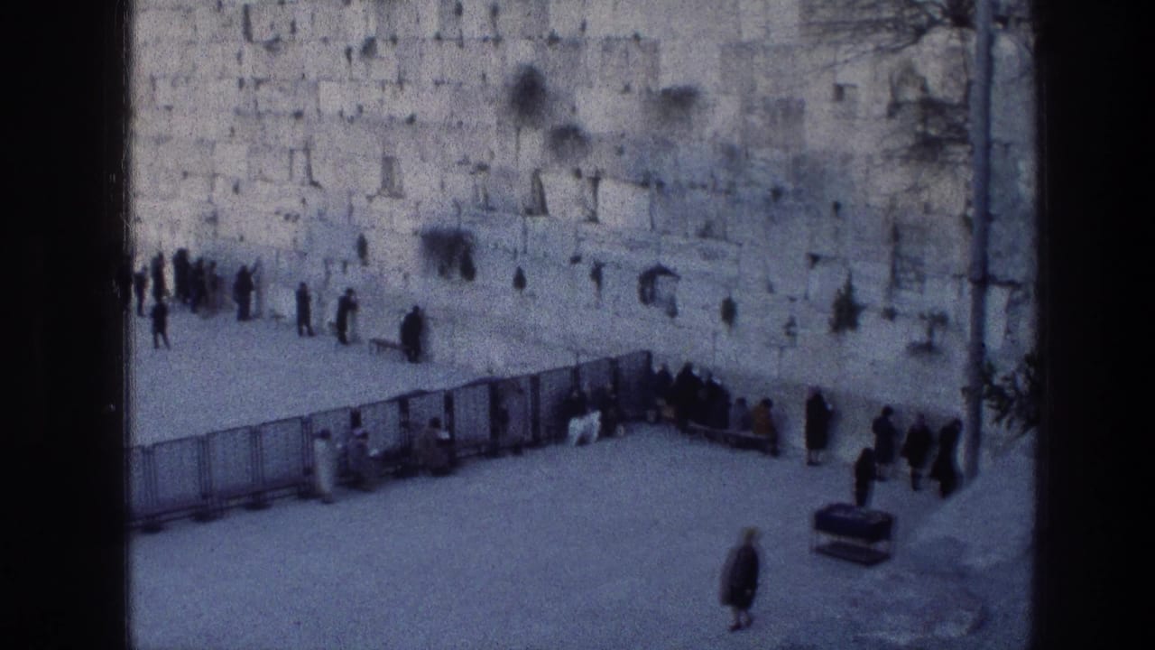 A wide courtyard view shows people near the Western Wall and a lone figure walking in front.
