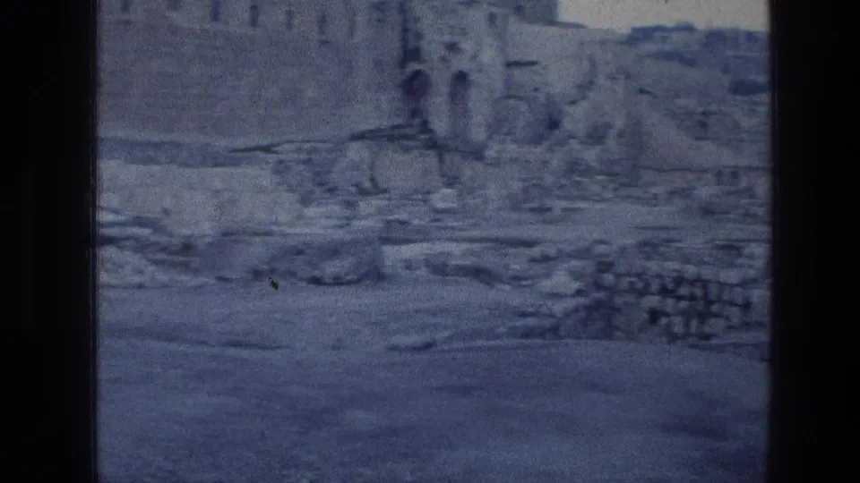 1976 8mm view of the Wailing Wall area in Jerusalem, showing weathered masonry, rubble, and open ground with no people visible.