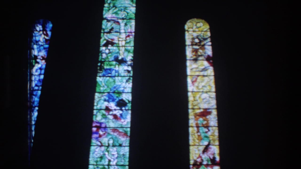 1976 Zurich 8mm frame showing tall arched stained-glass windows lit against a dark church interior.