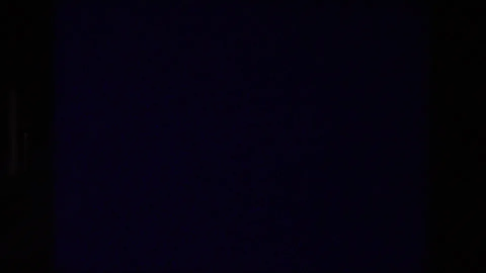 Dark 8mm frame with faint color cast and film texture at the start of a 1976 Zurich, Switzerland travel-title clip.