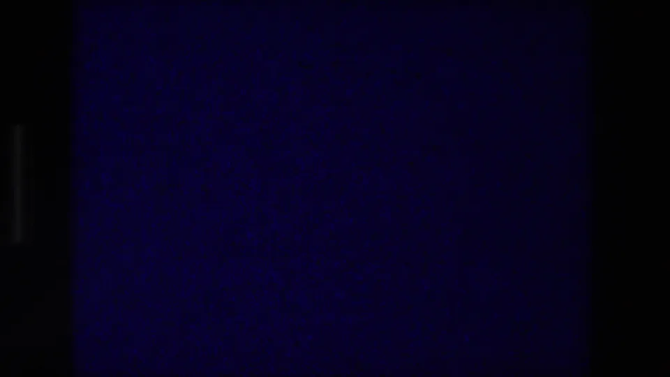 Blue 8mm projection frame near the reel ending, with dark borders, grain, and low-light color shift in the cinema room.