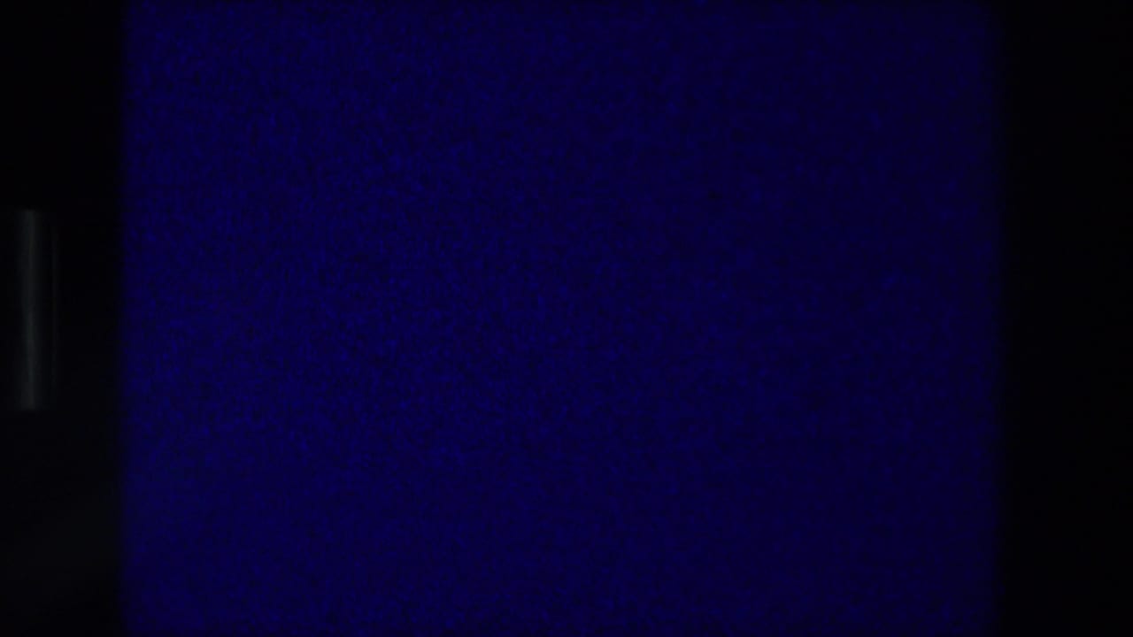 Final blue-toned 8mm projection frame after the Zurich Switzerland card, with grain, dark edges, and no visible figures.