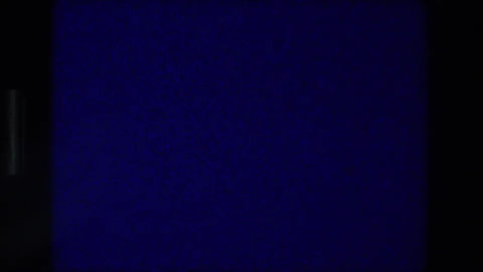 Final blue-toned 8mm projection frame after the Zurich Switzerland card, with grain, dark edges, and no visible figures.