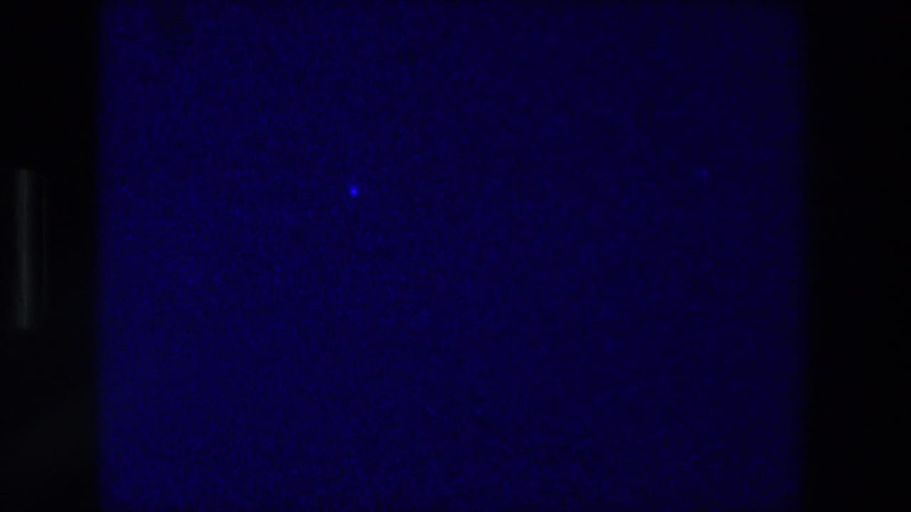 1976 Zurich 8mm frame showing a blue-purple close-up of squared paper or a drawn grid, partly obscured by dark film edges.