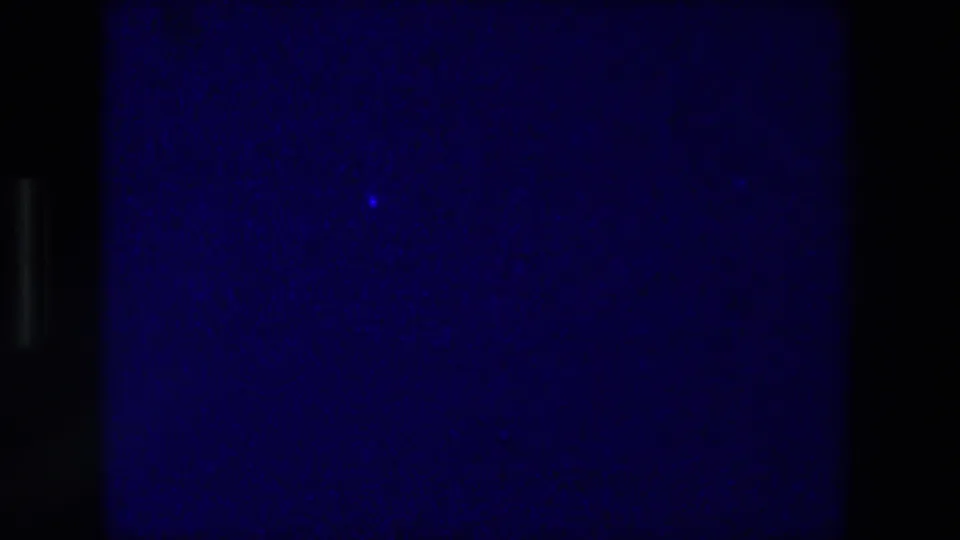 1976 Zurich 8mm frame showing a blue-purple close-up of squared paper or a drawn grid, partly obscured by dark film edges.