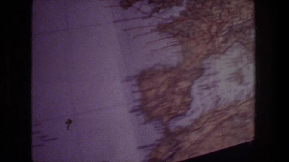 Close 8mm view of a textbook-style European map, with coastline outlines, grid marks, and a purple-tinted film look.