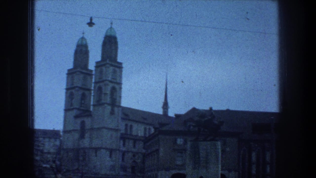 Blue-tinted 1976 Zurich view of Grossmunster-style twin towers with nearby roofs, a spire, and dark window framing.