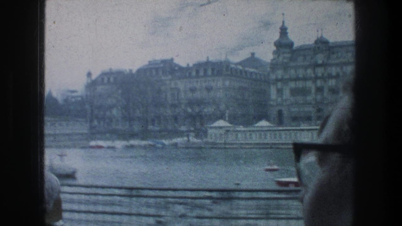 Zurich riverfront seen from a train window in 1976, with a man's glasses and profile at the right edge.
