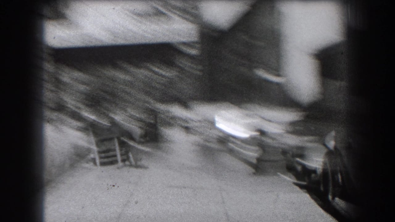 Blurred sidewalk view with parked cars, building steps, and a pedestrian at the edge of frame.